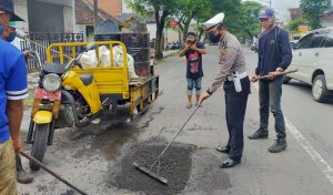 Anggota Polsek Genteng Ikut Serta Dalam Proses Perbaikan Jalan Raya Oleh Dinas PU